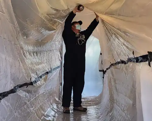 Pest Plus technician setting up tarps for a treatment.